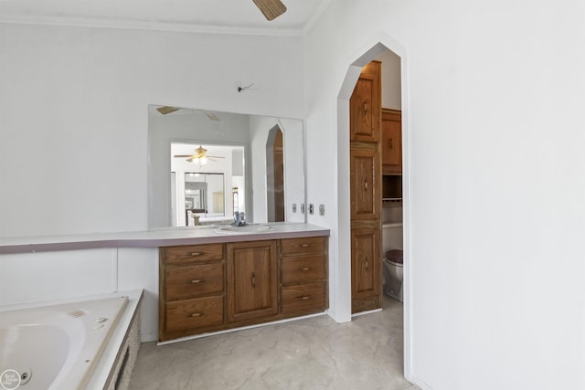 bathroom featuring a ceiling fan, vanity, a bath, ornamental molding, and toilet