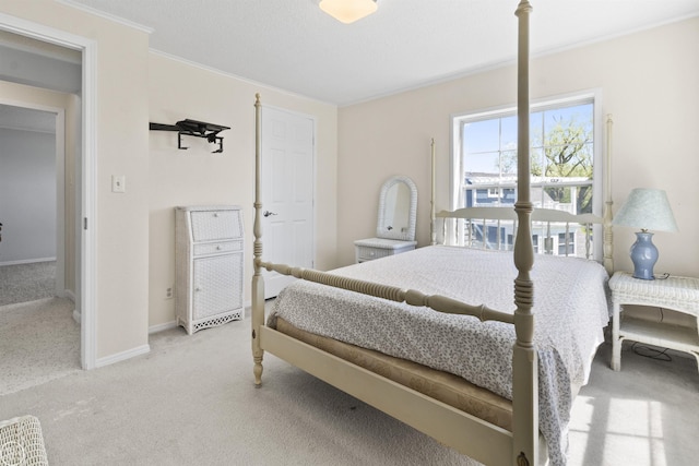 carpeted bedroom featuring ornamental molding and baseboards