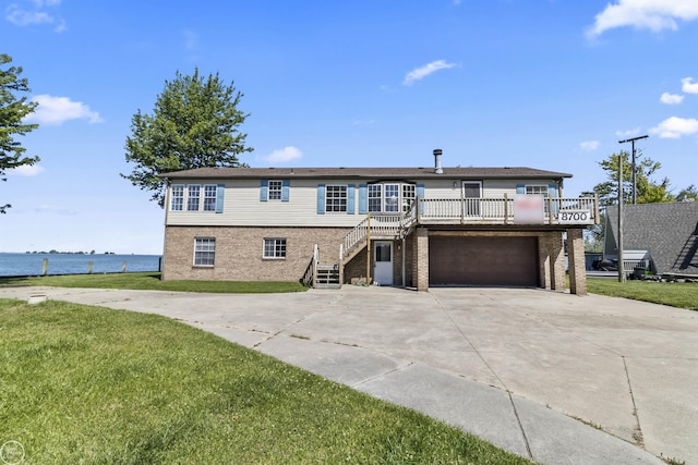 view of front of house featuring stairway, concrete driveway, a garage, and a front yard