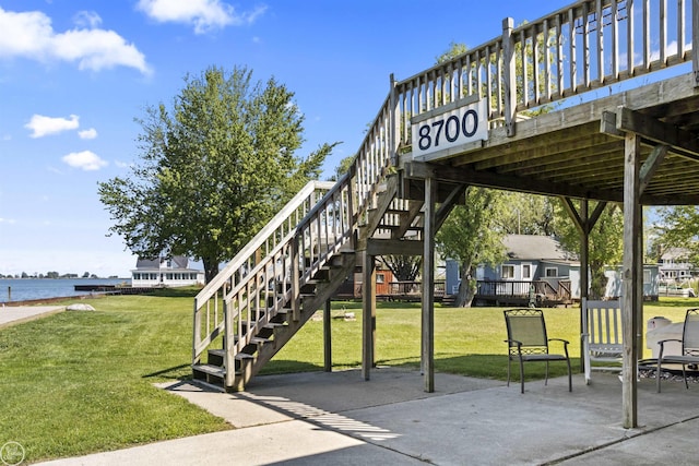 view of patio / terrace featuring a water view and stairs
