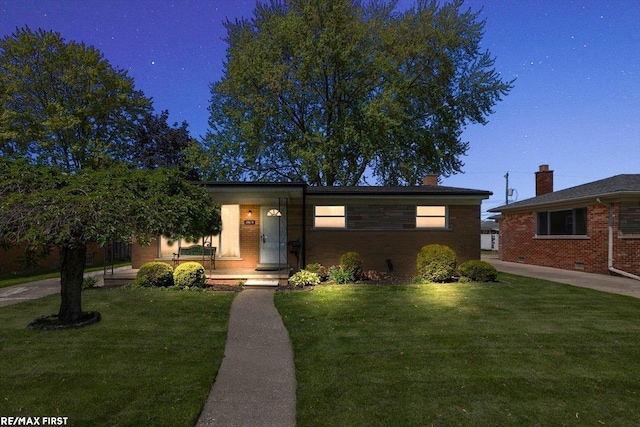 view of front facade with a front yard, brick siding, and a porch