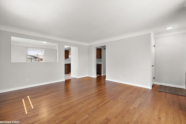 unfurnished living room featuring wood finished floors, baseboards, and recessed lighting