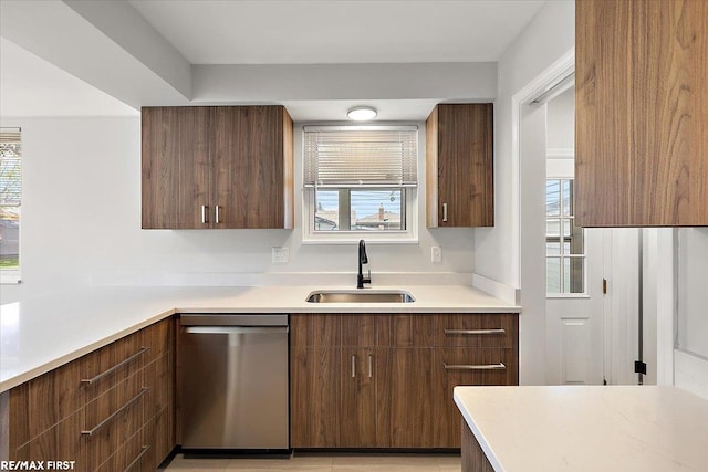 kitchen with dishwasher, a sink, modern cabinets, and light countertops
