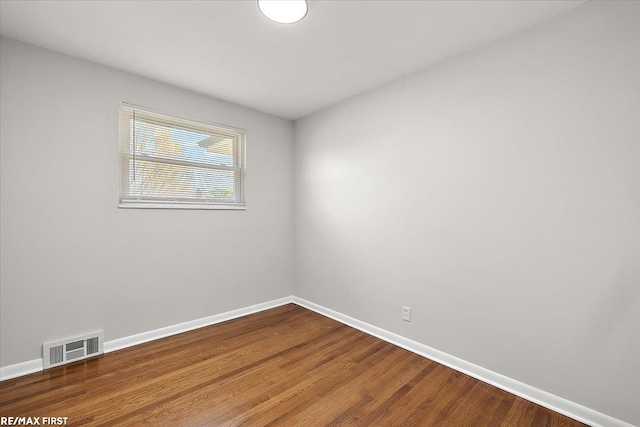 unfurnished room with baseboards and wood finished floors