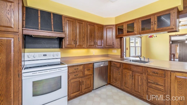 606 S 13th St, Gladstone, MI 49837 - kitchen featuring stainless steel dishwasher, white electric stove, a sink, and brown cabinetry