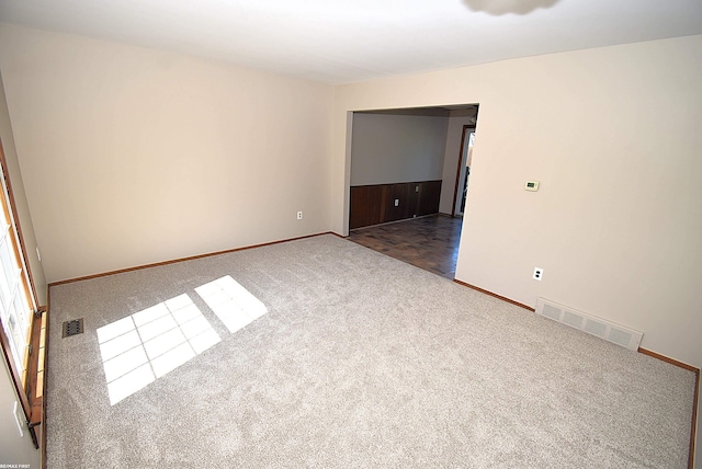 carpeted empty room featuring baseboards
