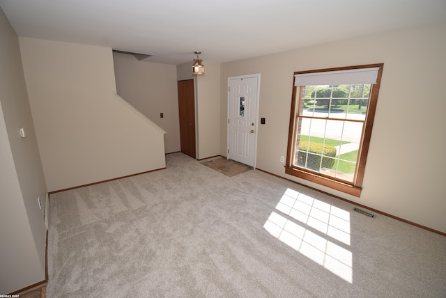 unfurnished room with carpet, stairway, and baseboards