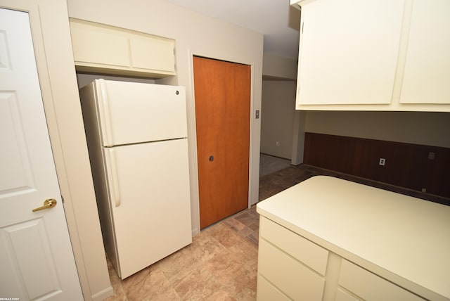 kitchen with freestanding refrigerator and light countertops