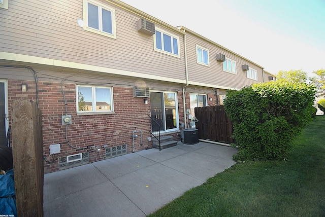 back of property featuring entry steps, a patio area, fence, brick siding, and cooling unit