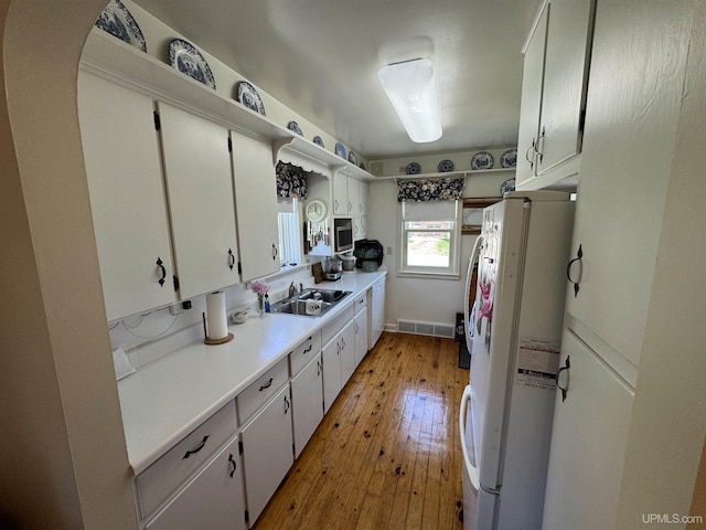 1100 Poplar Ave, Crystal Falls, MI 49920 - kitchen with freestanding refrigerator, a sink, stainless steel microwave, light wood finished floors, and light countertops