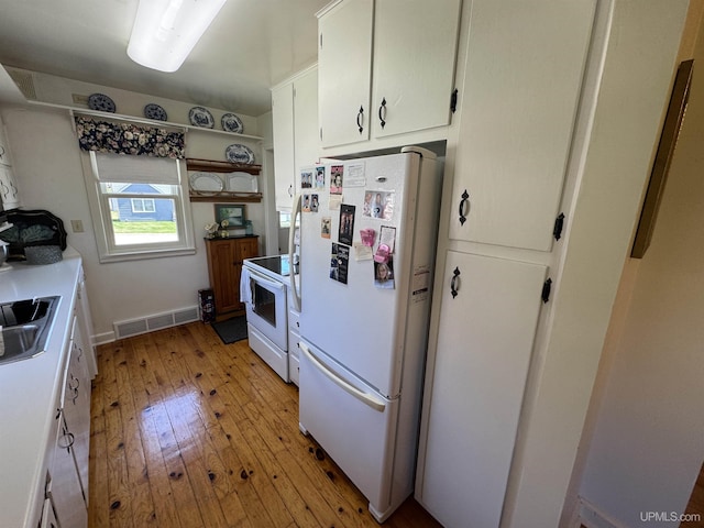 1100 Poplar Ave, Crystal Falls, MI 49920 - kitchen with white appliances, light wood-type flooring, white cabinetry, a sink, and open shelves