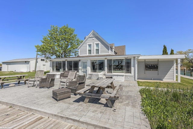 rear view of property featuring a sunroom and a patio