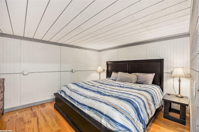 bedroom with wood ceiling, wood finished floors, and wood walls