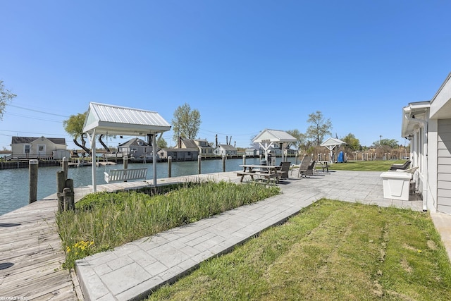 view of grassy yard with a dock and a water view