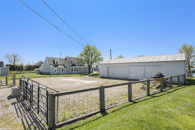 view of yard featuring an outbuilding, dirt driveway, a gate, and a garage