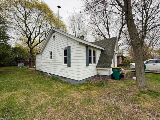306 N Ionia St, Gladwin, MI 48624 - view of side of property featuring a shingled roof and a chimney