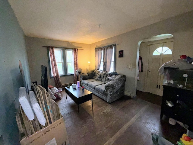 306 N Ionia St, Gladwin, MI 48624 - living room featuring dark wood-style flooring, arched walkways, and plenty of natural light