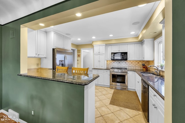 kitchen with black appliances, a sink, tasteful backsplash, white cabinetry, and light tile patterned flooring