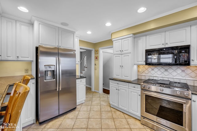 kitchen with appliances with stainless steel finishes, crown molding, decorative backsplash, white cabinetry, and baseboards