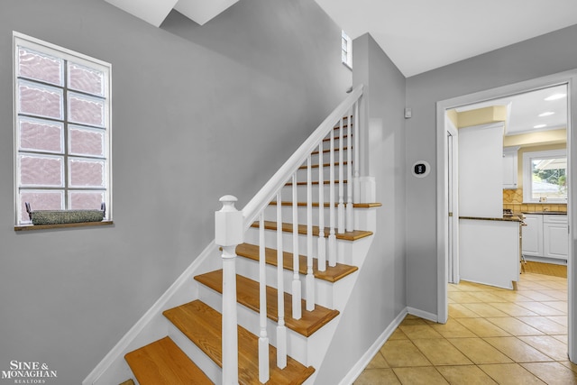 stairs featuring tile patterned flooring and baseboards