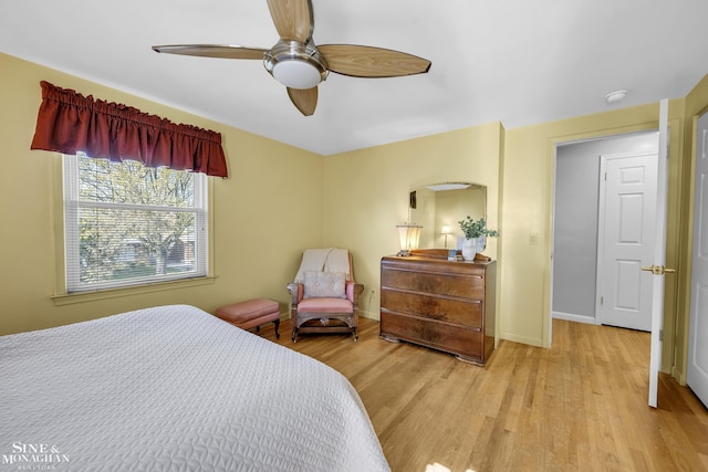 bedroom with light wood-style flooring, baseboards, and a ceiling fan