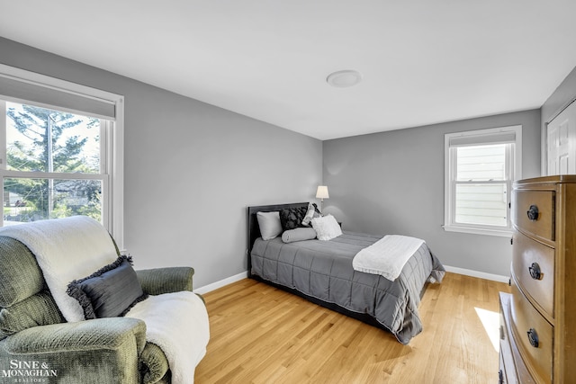 bedroom with light wood-type flooring and baseboards