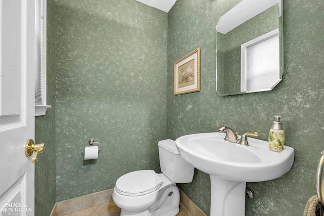 half bathroom featuring toilet and tile patterned flooring