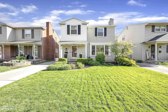 traditional-style home featuring covered porch, a front lawn, a chimney, and brick siding