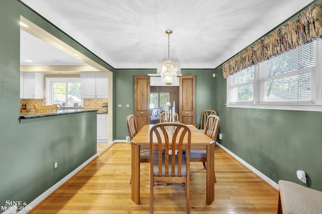 dining room featuring a chandelier, healthy amount of natural light, and light wood-style floors