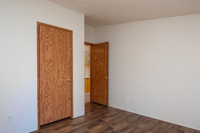 1448 W Sian Dr, Sanford, MI 48657 - unfurnished room featuring a textured ceiling and dark wood-style flooring