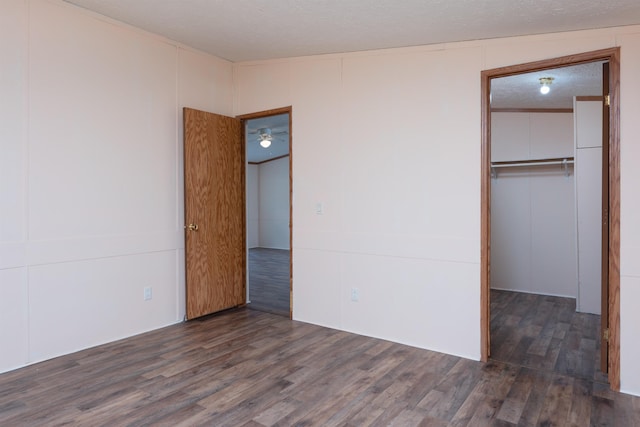 1448 W Sian Dr, Sanford, MI 48657 - unfurnished bedroom with wood finished floors, a closet, and a textured ceiling