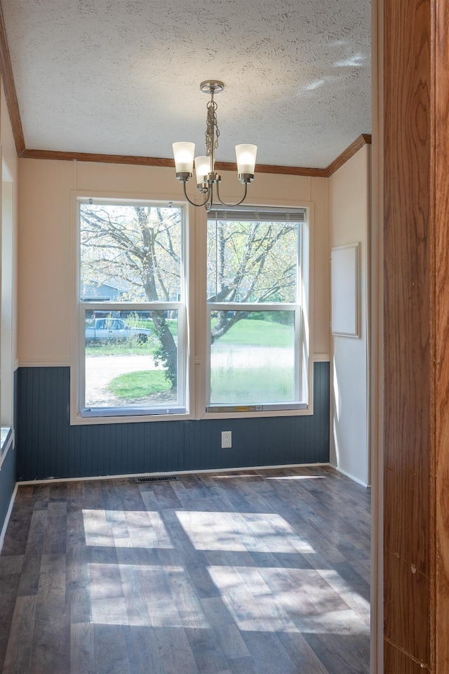 1448 W Sian Dr, Sanford, MI 48657 - unfurnished dining area featuring a textured ceiling, a chandelier, wainscoting, ornamental molding, and dark wood finished floors