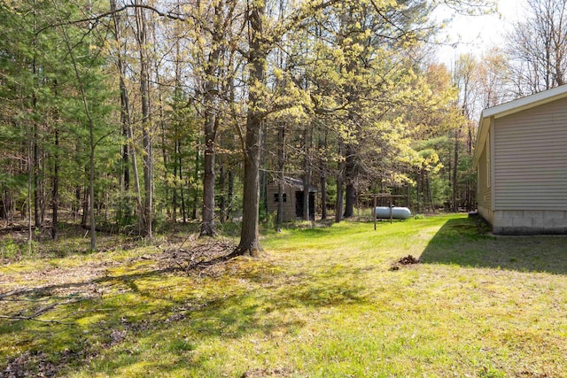 1448 W Sian Dr, Sanford, MI 48657 - view of grassy yard featuring a wooded view and an outdoor structure