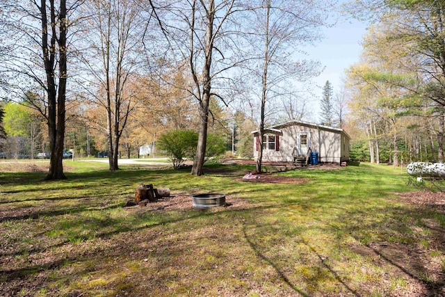 1448 W Sian Dr, Sanford, MI 48657 - view of grassy yard with an outdoor fire pit