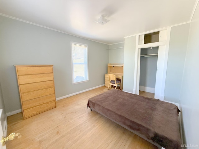 bedroom featuring crown molding, wood finished floors, a closet, and baseboards