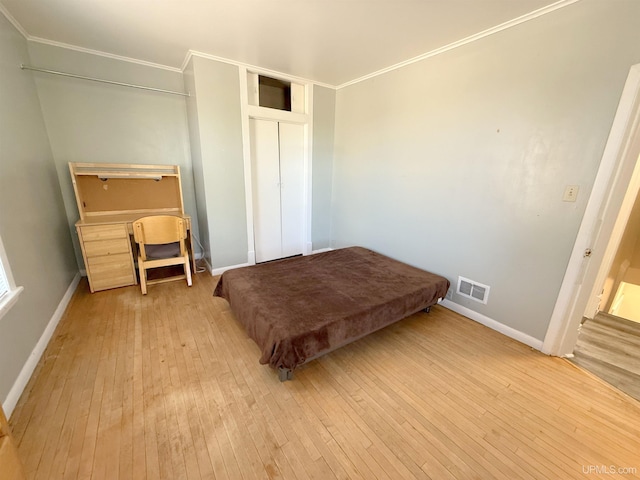 bedroom featuring wood-type flooring, ornamental molding, and baseboards
