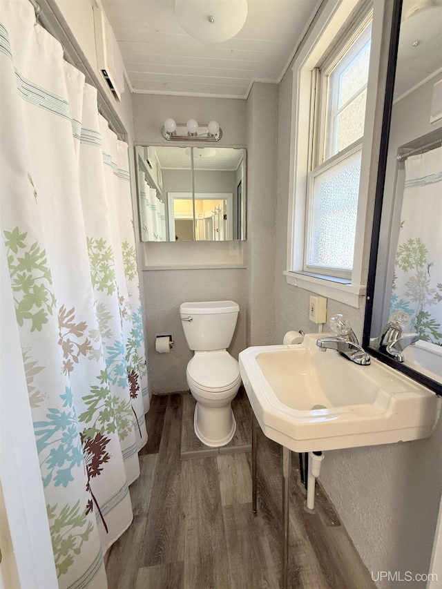 full bath featuring wood finished floors, toilet, and crown molding
