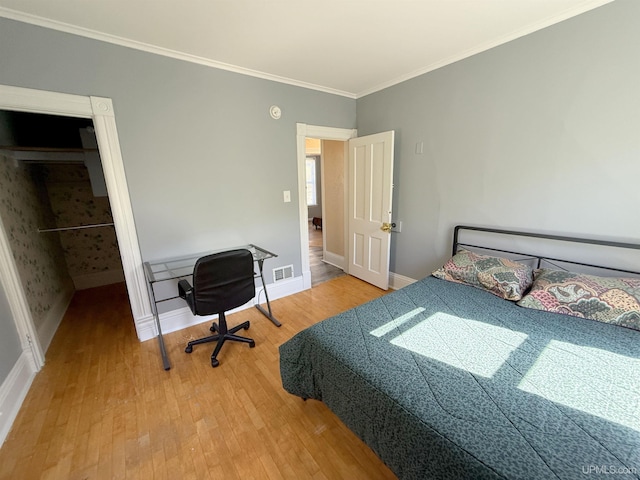 bedroom with light wood finished floors, baseboards, and crown molding