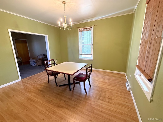 dining area with crown molding, a chandelier, baseboards, and light wood-style flooring