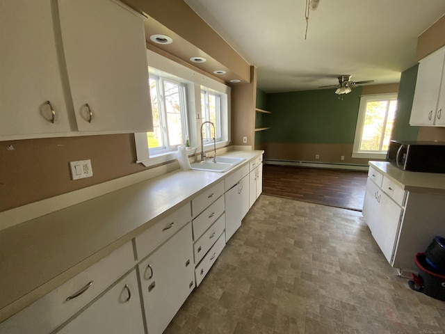 6053 Van Dyke Rd, Brown City, MI 48416 - kitchen with a sink, stainless steel microwave, a baseboard radiator, white cabinetry, and light countertops