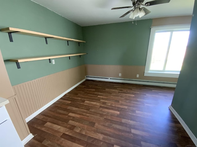 6053 Van Dyke Rd, Brown City, MI 48416 - unfurnished room with a baseboard heating unit, ceiling fan, wood finished floors, and wainscoting