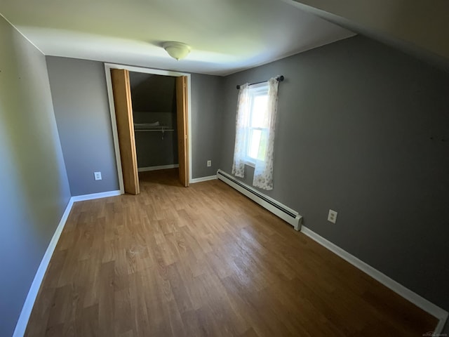 6053 Van Dyke Rd, Brown City, MI 48416 - unfurnished bedroom with a baseboard radiator, wood finished floors, a closet, and baseboards