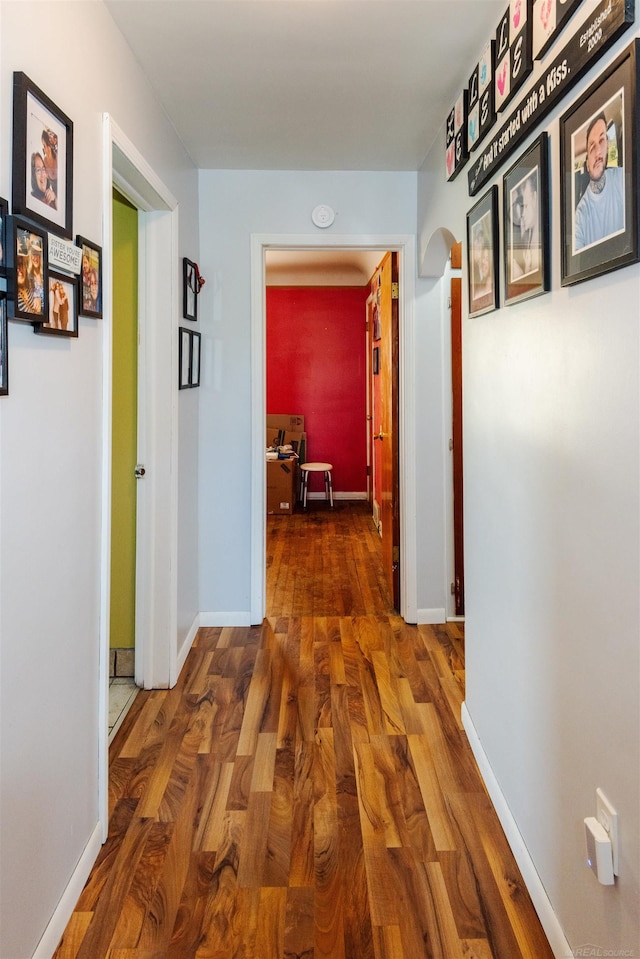 410 E Nicol Rd, Sandusky, MI 48471 - hallway with wood finished floors, arched walkways, a desk, and baseboards
