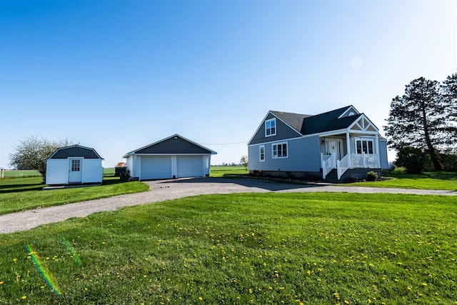 410 E Nicol Rd, Sandusky, MI 48471 - view of front of house featuring an outdoor structure, a detached garage, a front lawn, and a storage unit