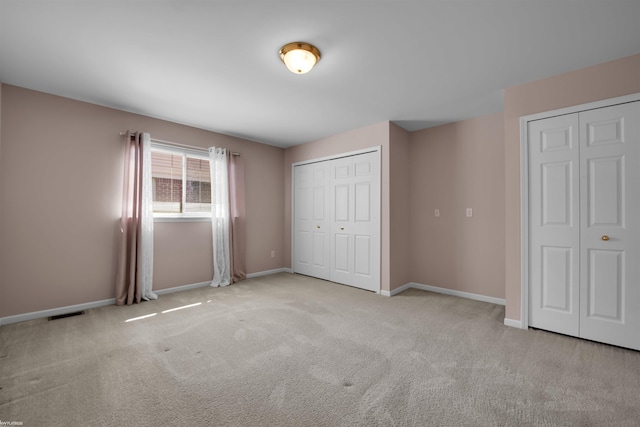unfurnished bedroom featuring carpet floors and baseboards