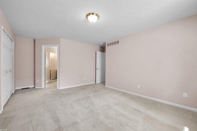 unfurnished bedroom featuring baseboards, light carpet, and connected bathroom