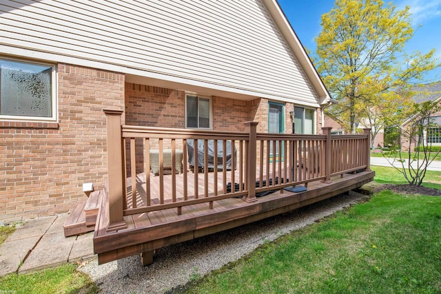 wooden deck featuring a lawn