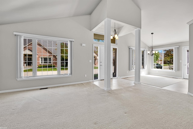 unfurnished living room with a chandelier, carpet floors, baseboards, decorative columns, and high vaulted ceiling