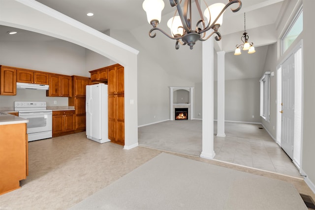 kitchen with white appliances, under cabinet range hood, brown cabinets, a chandelier, and open floor plan