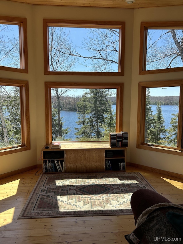 25393 Campsite Dr, Michigamme, MI 49861 - living room featuring a water view, a high ceiling, baseboards, and hardwood / wood-style flooring